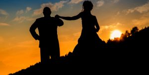 Illustrasjon av mann og dame som holder hender i solnedgang