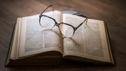 foto av en bok med briller som ligger oppå