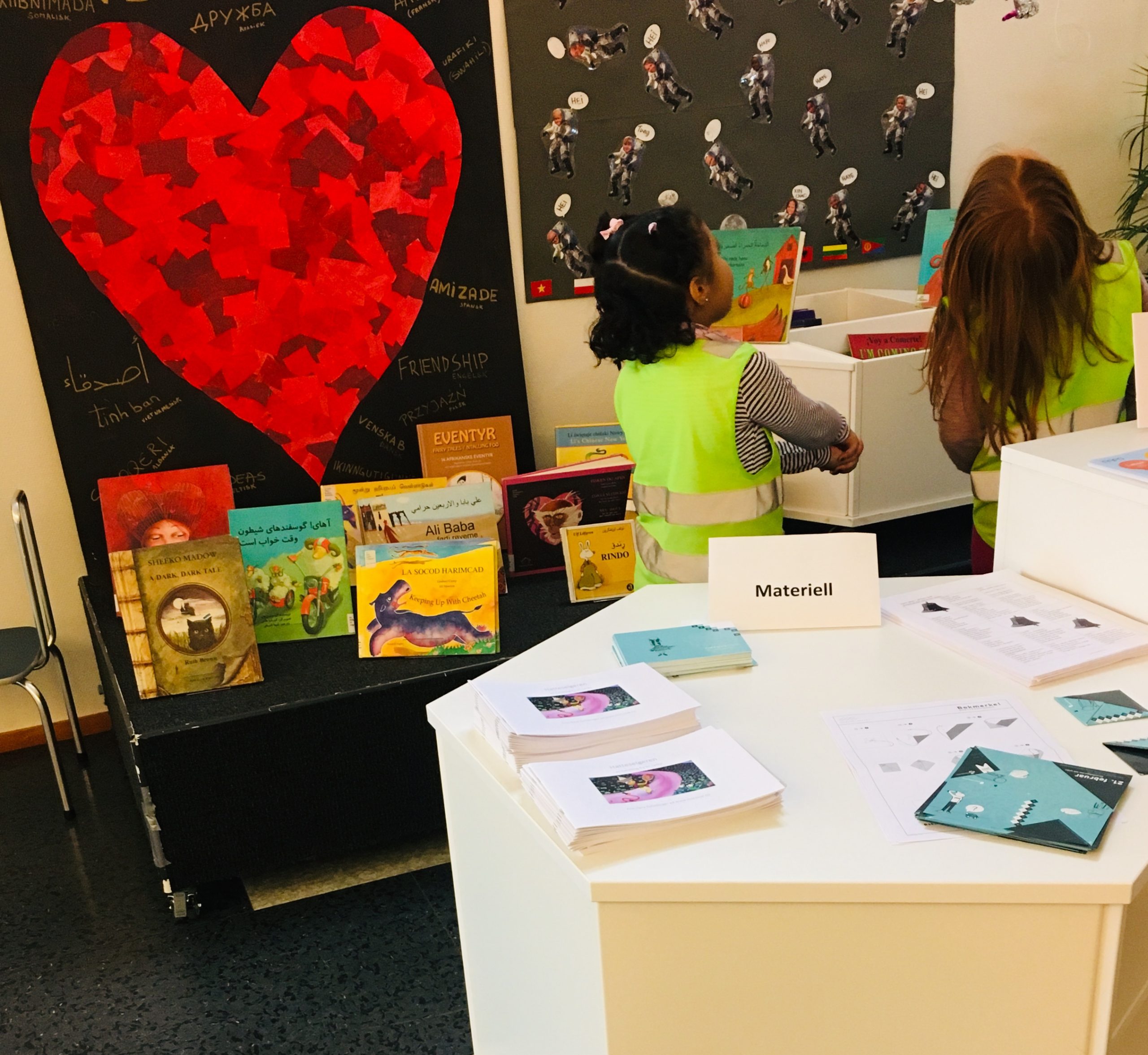 To barn med gul vest ser p&aring; plakater 