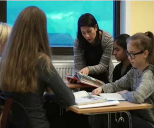 Bilde av en lærer som hjelper elever