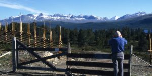 foto av en gammel mann som står og ser utover noen fjell