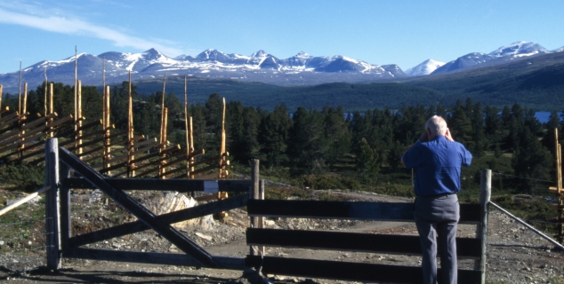 foto av en gammel mann som står og ser utover noen fjell