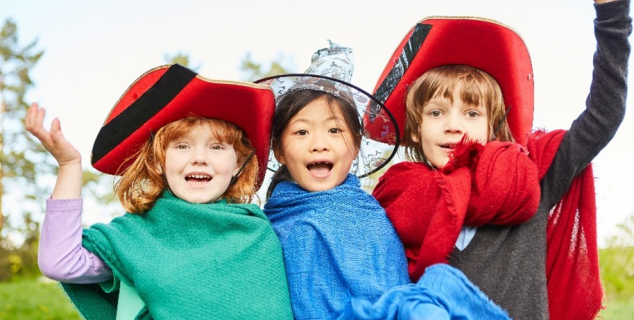 Tre barn som kler seg ut 